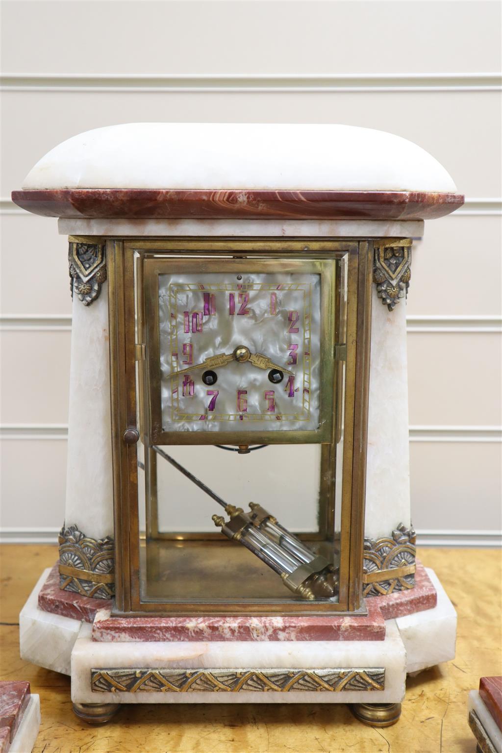 An Art Deco rouge and white marble clock garniture